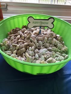 a green bowl filled with muddy dog chow next to a sign that says puppy show