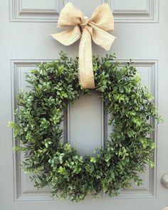 a wreath with a bow hanging on the front door