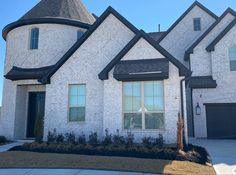 a white brick house with black trim and windows