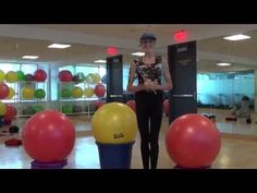 a woman is standing in front of some exercise balls