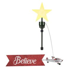 a light that is attached to a pole with a star on it and the word believe written