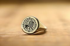 Embrace the majestic spirit of the savannah with our Tribal African Lion Engraved Gold Signet Ring. This bold statement piece beautifully captures the essence of the king of the jungle through a striking tribal design, symbolizing courage, strength, and royal authority. Intricately engraved on a round-shaped gold signet ring, this custom lion ring resonates with those who admire the lion's majestic presence and the rich cultural heritage it represents. Perfect for anyone drawn to the powerful sy Lion Signet Ring, Dna Jewelry, Lion Ring, Gold Lion, African Lion, Fancy Gifts, Gold Signet Ring, Unisex Ring, Unique Handmade Jewelry