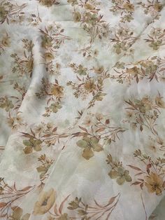 a white and brown floral print fabric with small flowers on the bottom half of it