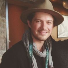 a man wearing a hat and scarf posing for the camera