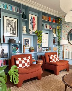 a living room filled with furniture and bookshelves covered in pictures on the walls