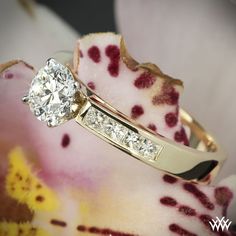 a diamond ring sitting on top of a flower