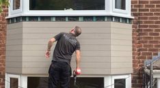 a man is painting the side of a house