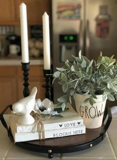 a tray with books, candles and a potted plant sitting on top of it