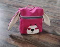 a small pink bag with a bunny face on it