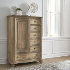 a wooden dresser with drawers in front of a window and rug on the floor next to it