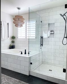 a white tiled bathroom with a walk in shower