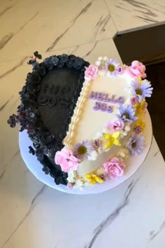 there is a cake decorated with flowers and the word hello boo on it's side