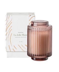 a candle in front of a box with the label la jolie museum on it