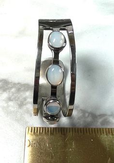 "Thank you for viewing. Glowing Opaline glass, that also looks like moonstone, is set in a sterling silver bangle. This will fit a small wrist. If you can wear a 6 inch bracelet. Has a Tasco maker mark that is indiscernible. Very stylized script reading \"Sterling 925\" 28.39 grams Sterling Silver and Glass Fits a 6 inch wrist Circa 1960" Adjustable Retro Silver Bracelet, Retro Silver Bangle Bracelet, Maximalist Jewelry, Script Reading, Vintage Sterling Silver Nickel-free Bangle, Vintage Hallmarked Sterling Silver Bangle, Vintage Silver Bangle, Collectible, East Peoria, Sterling Silver Bangle