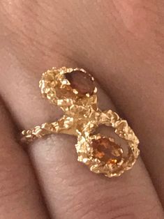 Rare Vintage 14kt Gold Brutalist Ring With Two Citrine Stones. Unique brutalist twist figure eight dome with two oval seated orange stones. Make a statement with this unique chunky piece of jewelry. Markings: SECO 14k Measurements: Ring Size 6, Stones- 5.4mm each Total Weight: 5.26 grams Condition: Great Vintage condition, ready to wear. Please review the photos for visual detail and let me know if you have any further questions prior to purchase. I don't offer returns or exchanges. USA sales on Gold Open Ring With Topaz Gemstone, Formal Gold Ring With Yellow Sapphire, Formal Gold Sapphire Ring With Yellow Sapphire, Gold Birthstone Ring With Topaz Gemstone, Gold Topaz Birthstone Ring With Gemstone, Gold Citrine Heirloom Rings, Unique Yellow Gold Topaz Ring For Formal Occasions, Yellow Gold Sapphire Open Ring In Unique Style, Yellow Gold Citrine Rings For Anniversary