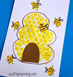 a handprinted card with bees and a tree made out of yellow paper on a blue background