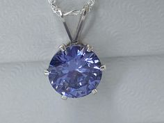 December birthstone, beautiful Tanzanite cubic zirconia necklace. 8mm round gemstone hand set in 6 prong sterling silver pendant.  Tanzanite pendant comes on an 18 inch sterling silver figaro chain. Tanzanite cz gemstone is 1.85 carat total weight.   This sparkly pendant necklace is a perfect gift idea! This gorgeous necklace comes in a gift box and is ready to be given to that special someone.  Great gift idea for a birthday, an anniversary, Valentine's Day or any occasion.  Great for mothers, sisters, daughters or friends!  What a great personalized gift! IF THIS IS A GIFT, PLEASE WRITE THE NOTE (TO, FROM, MESSAGE) IN THE CART AND I WILL SEND A SMALL CARD TO GO WITH THE PACKAGE Silver Round Birthstone Necklace For Birthday Gift, Gift Jewelry With Round Stone And Prong Setting, Silver Jewelry With Prong Setting For Birthday, Silver Sterling Silver Round Cut Birthstone Necklace, Gift Diamond Cut Birthstone Necklace, Gift Birthstone Necklace With Diamond Cut, Gift Round Diamond Cut Birthstone Necklace, Sterling Silver Jewelry With Prong Setting For Birthday, Silver Solitaire Necklace As Gift