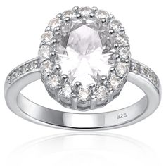 a white diamond ring with diamonds around the band and an oval center surrounded by small round stones