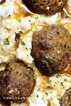 some meatballs and mashed potatoes are in a sauce with grated parmesan cheese