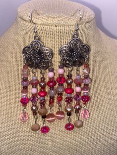 These earrings will put you in the very trendy color of pink. Strands of beautiful pink, purple and peach beads drip down from intricate silver tone flowers. Beads include vintage, modern and glass beads. These are on the longer side but they are not at all heavy. Pink Flower Dangle Earrings With Beads, Bohemian Pink Flower Earrings With Dangling Beads, Pink Bohemian Dangling Beads, Purple And Peach, Pink Flower-shaped Jewelry With Dangling Beads, Pink Multi-strand Jewelry With Polished Beads, Flowers Beads, Vintage Modern, Trendy Colors