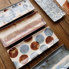 four plates sitting on top of a wooden table covered in brown and blue polka dots