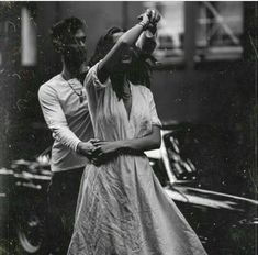 an old black and white photo of two people holding each other's arms in the air