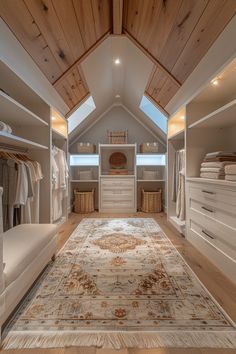 a walk in closet with lots of white furniture and wooden ceilinging, along with an area rug on the floor