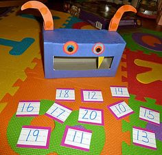 a blue box sitting on top of a colorful floor covered in numbers and monsters with eyes