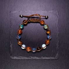 | EDITOR'S NOTE | When I wear it, the tones of this bracelet make me feel like I'm in the wild west, a cowboy galloping through the lands of Texas, to match with a pair of denim and a brown leather jacket |DETAILS & CARE| - Handmade in Italy - Tiger's Eye 8 mm AAA South Africa - Chrysocolla 8 mm AA Mexico - Carnelian 8 mm AAA India - Kyanite 8 mm AA Kenya (Machakos) - it is hand-woven with a brown waxed polyester thread using the macramé technique - Sliding knot closure, easy to put on and take Leather Jacket Details, Sliding Knot Closure, Jacket Details, Far West, The Wild West, Tanning Lotion, Sliding Knot, Brown Leather Jacket, Semi Precious Stones