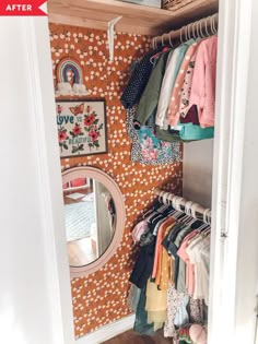 an open closet with clothes hanging on the wall and a round mirror in front of it