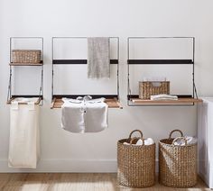 two baskets and towels are hanging on the wall next to some shelves with towel racks