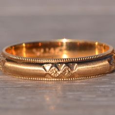 two gold wedding bands sitting on top of each other