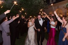 a bride and groom walk down the aisle with sparklers in their hands as they exit