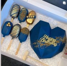 blue and gold birthday cake pops in a box