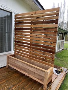 a wooden bench sitting on top of a wooden deck next to a window and grass