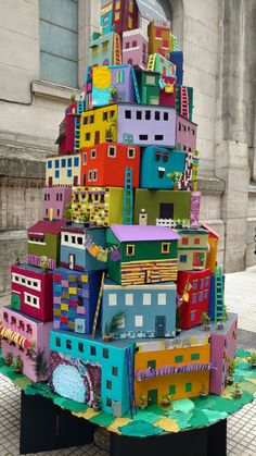 a multicolored cardboard christmas tree with buildings on it