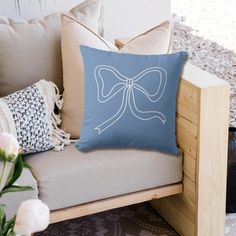 a blue pillow sitting on top of a wooden bench next to pillows and vases