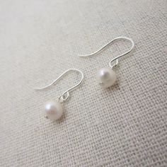 Dainty and classic, these sterling silver earrings are made with real pearls in a creamy off-white color. The TINY pearls are approximately 5mm. Each pair comes in a gift box, perfect for gift giving.  Comes with hypo-allergenic and comfortable rubber earring stops to keep hooks securely in your ear.  Shown on a life-sized mannequin for size-reference. Total earring length is approximately 3/4 inch.  Please note, these are made with genuine freshwater pearls so sizes, shapes, and coloring will v Minimalist Nickel-free Pearl Earrings For Formal Occasions, Minimalist Hypoallergenic Pearl Earrings For Formal Events, Classic Pearl Drop Earrings, Classic Everyday Pearl Drop Earrings, Classic Everyday Nickel Free Pearl Earrings, Classic Nickel-free Pearl Earrings, Classic Teardrop Nickel-free Pearl Earrings, Minimalist White Gold Pearl Earrings, Classic Silver Pearl Earrings