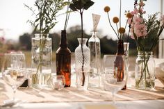 there are many vases with flowers in them sitting on the dining table, ready to be served