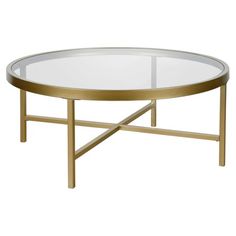 an oval glass coffee table with gold metal legs