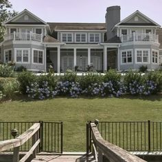 a large white house sitting on top of a lush green field