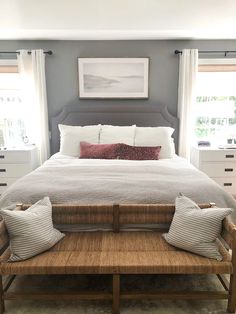 a large bed sitting in a bedroom next to two windows