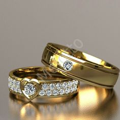 two gold wedding rings with heart shaped diamonds