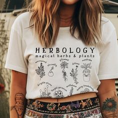 H e r b o l o g y :  the study or collecting of herbs. *W A S H   D A Y* Please follow these instructions carefully to avoid fading and cracking of the print, and shrinking the garment that can occur if you wash or dry it on a high setting. *Machine-wash cold, inside-out on a gentle cycle with a mild detergent and like colors. *Use non-chlorine bleach only when necessary. You shouldn't use any fabric softeners or dry-clean the items. *Tumble-dry on a low cycle, but hang-dry works best. *Don't iron the print. * 100% combed and ring-spun cotton (Heather colors contain polyester) * Ash color is 99% combed and ring-spun cotton, 1% polyester * Heather colors are 52% combed and ring-spun cotton, 48% polyester * Athletic and Black Heather are 90% combed and ring-spun cotton, 10% polyester * Heath Magical Plants, Jean Jacket Outfits, Nashville Outfits, Boho Fashion Summer, Black Jeans Outfit, College Shirts, Floral Tee, Branding Photoshoot, The Study