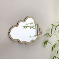 a mirror mounted to the side of a wall next to a potted bamboo plant