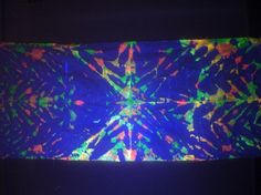 a tie - dyed piece of art is shown in the dark