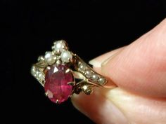 "A royal arrangement of garnet and seed pearls on this elegant Victorian ring.Three seed pearls crown the .40 oval faceted garnet.Two diagonal shoulder pieces with four inset seed pearls complement this gorgeous setting.Shorter, gold plumed braces balance out the design.Eight prongs hold the garnet and thirteen prongs hold the three pearls in place. Inside the ring band is inscribed,\"G. to A.\" in Victorian script. What a romance this must have been! Ring size: 7 US, N 1/2 UK, 14 Japan, China, Pearls Crown, Rose Gold Emerald Ring, Vintage Opal Ring, Pearls Ring, Gold Emerald Ring, Opal Ring Vintage, Wedding Band Engraving, Victorian Ring, Emerald Ring Gold