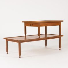 a small wooden table with one drawer on the top and two drawers on the bottom