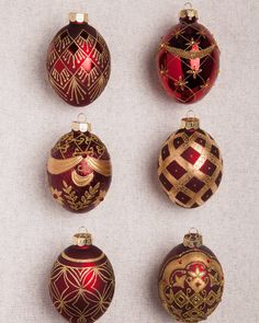 six red and gold christmas ornaments hanging on a wall