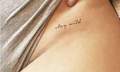 a woman's stomach with the word stay wild tattooed on her left side belly